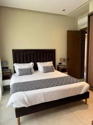 a bedroom with a large bed with a wooden headboard at Luxury villa Noria golf club in Marrakech