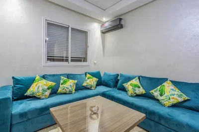 a blue couch in a living room with a coffee table at Family apartment Jardins Chrifia in Marrakech