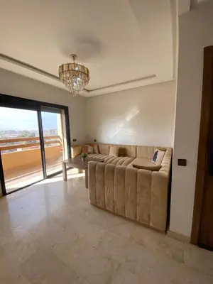 a large living room with a couch and a chandelier at Appartement moderne confortable 2 chambres près de Marrakech Gueliz piscine in Marrakech
