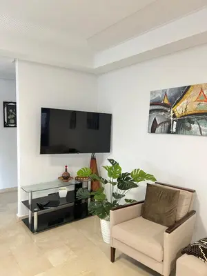 a living room with a couch and a tv on a wall at Quite place for your vacation in Marrakech