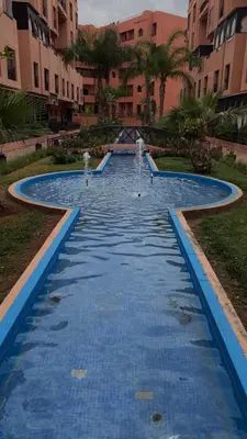a large pool with blue water in a building at Quite place for your vacation in Marrakech