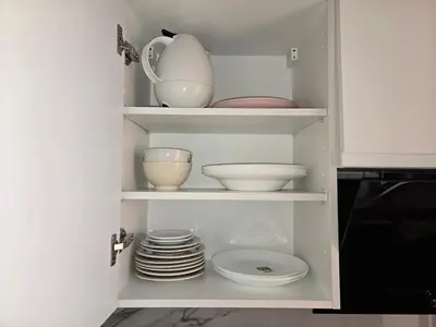 a cupboard with plates and bowls and dishes in it at Quiet and comfortable apartment in Marrakech