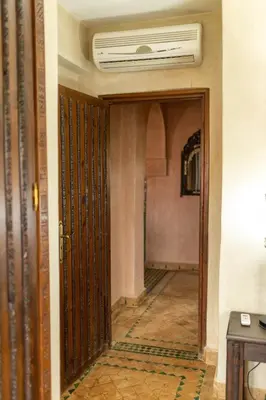 a hallway with an open door in a building at la roseraie Marrakech in Marrakech