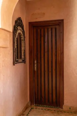 a wooden door with a mirror on a wall at la roseraie Marrakech in Marrakech