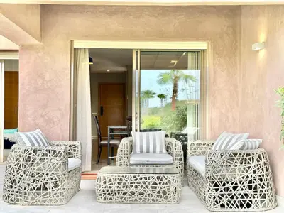 a patio with wicker chairs on a porch at Comfy Luxe Stay Golf View Marrakech in Marrakech