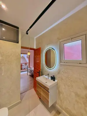 a bathroom with a sink and a glass shower at Riad Authentique à quelques pas de Jamaa El-Fna in Marrakech