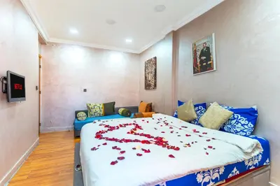 a bedroom with a large bed with red flowers on it at Lely appartement 2min de là garé in Marrakech
