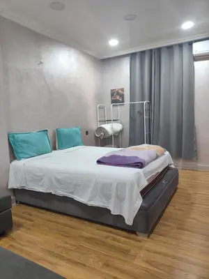 a bedroom with a large bed with blue pillows at Lely appartement 2min de là garé in Marrakech