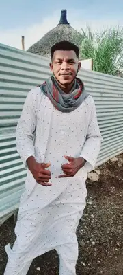 a man dressed in white standing next to a building at السودان in Marrakech