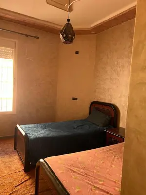 a bedroom with two beds and a chandelier at Modern Apartment 5 Min from Airport & Secure in Marrakech