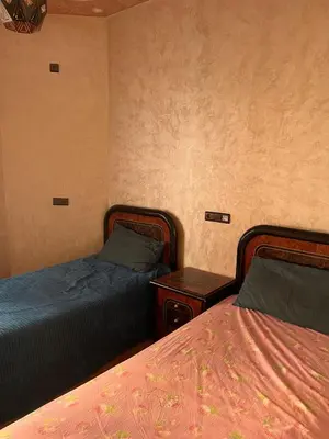 a bedroom with two beds and a night stand with two beds at Modern Apartment 5 Min from Airport & Secure in Marrakech