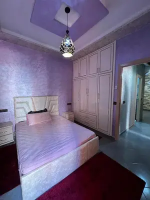 a bedroom with a large bed with purple walls at Modern Apartment 5 Min from Airport & Secure in Marrakech
