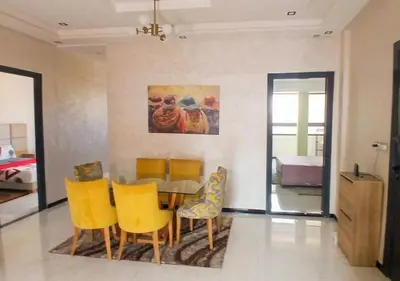 a dining room with a table and yellow chairs at Appart zénith in Marrakech