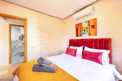 a bedroom with a large bed with red pillows at Appartement chic et confortable au cœur de Gueliz in Marrakech