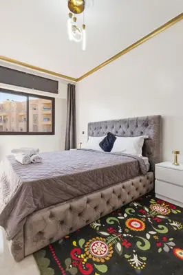 a bedroom with a large bed and a rug at Cosy 2BR Appartment, in City Center, AC, Iptv in Marrakech