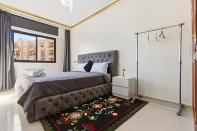 a bedroom with a bed and a rug at Cosy 2BR Appartment, in City Center, AC, Iptv in Marrakech