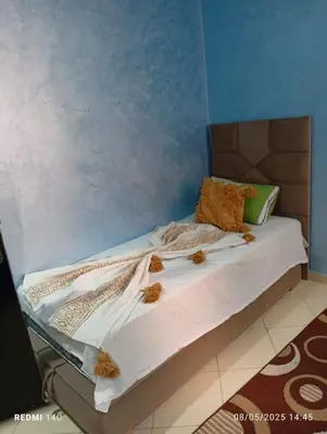 a bed in a room with a blue wall at Appartement Marrakchi in Marrakech