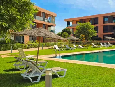 a resort with lounge chairs and a swimming pool at Appartement KENZ Nouria avec piscine in Marrakech
