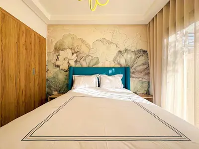 a bedroom with a large bed with a blue headboard at Appartement KENZ Nouria avec piscine in Marrakech