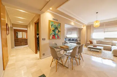 a dining room and living room with a table and chairs at Elegant & Cozy Luxury Apartment Hivernage, Pool City Center in Marrakech
