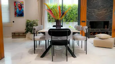 a dining room table with chairs and a vase of flowers at villa argana golf in Marrakech