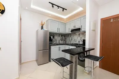 a kitchen with white cabinets and a stainless steel refrigerator at Red City Elegant Stay in Marrakech