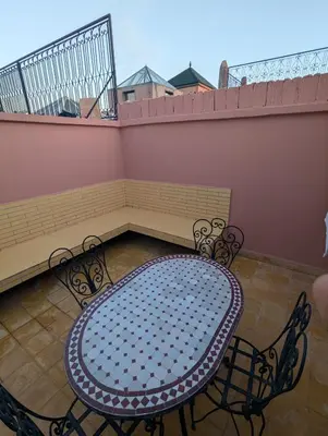 a patio with a table and chairs on a balcony at Almohafidon room 2 in Marrakech