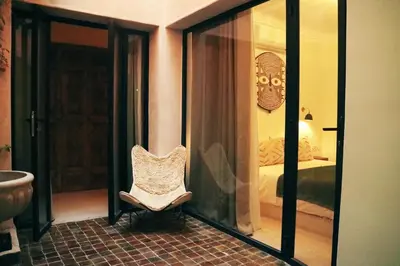 a room with a chair in a room with a bedroom at Dar Helen in Marrakech