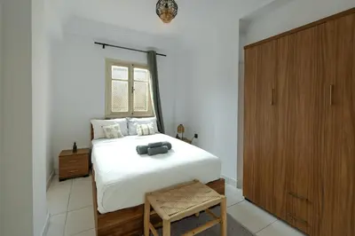 a bedroom with a white bed and a wooden cabinet at Modern studio with terrace in Marrakech
