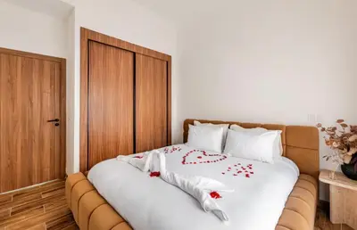 a bed with white sheets and red flowers on it at Premium Holliday Marrakesh in Marrakech