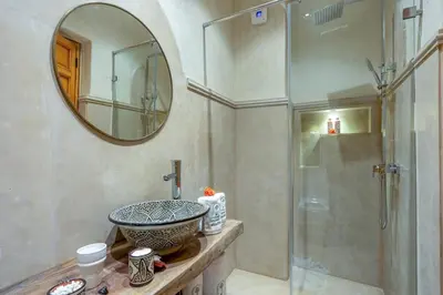 a bathroom with a sink and a glass shower at Riad Secret De Medina in Marrakech
