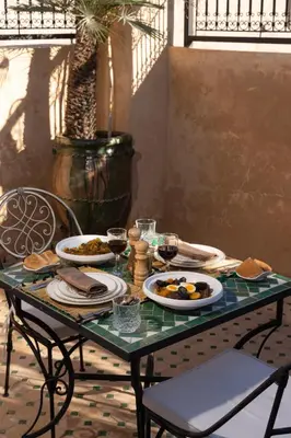 a table with plates of food and glasses of wine at Riad Secret De Medina in Marrakech