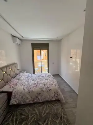 a bedroom with a bed in a white room at Apparemment cosy pour famille in Marrakech