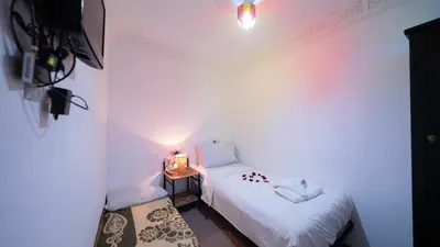 a room with two beds and a table with a lamp at Mizo House in Marrakech