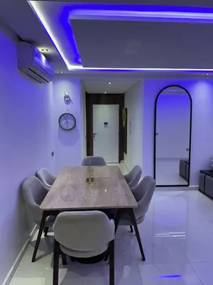 a dining room with a table and chairs and purple lighting at Prestige Gueliz city centre appartement in Marrakech