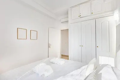 a white bedroom with a bed and white cabinets at Luxe et calme en plein centre de Marrakech in Marrakech
