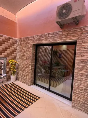 a room with a brick wall with a large glass window at Dar des étoiles in Marrakech