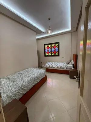a bedroom with two beds and a stained glass window at Dar des étoiles in Marrakech