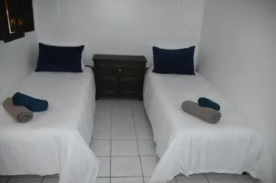 two beds in a room with blue pillows at Riad authentique dans une résidence sécurisée in Marrakech