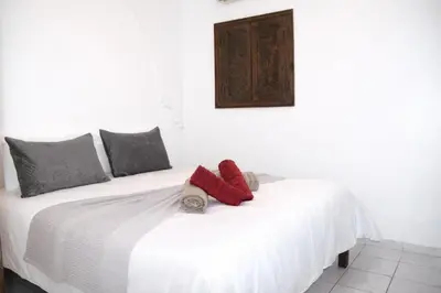 a white bed with two red pillows on it at Riad authentique dans une résidence sécurisée in Marrakech