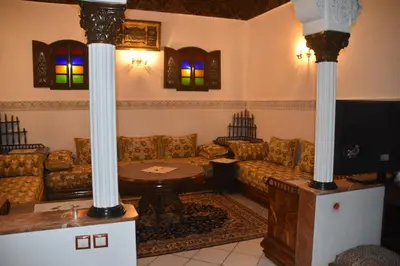 a living room with a couch and a table at Riad authentique dans une résidence sécurisée in Marrakech