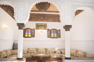 a living room with a couch and two columns at Riad authentique dans une résidence sécurisée in Marrakech