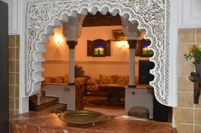 a living room with a table with a mirror at Riad authentique dans une résidence sécurisée in Marrakech