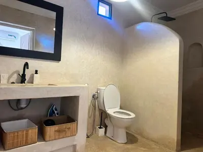a bathroom with a toilet and a sink and a mirror at Villa Léa 2 Marrakech in Marrakech