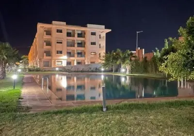 a building at night with a pond in front of it at Casaterra Luxury apartment with pool & home-cinema in Marrakech