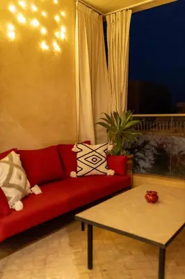 a living room with a red couch and a table at Casaterra Luxury apartment with pool & home-cinema in Marrakech