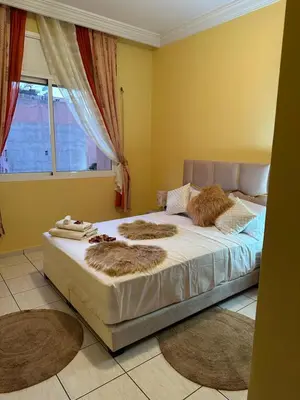 a bedroom with a bed with furry pillows and a window at Appartement, centre-ville, Marrakech, Gueliz in Marrakech