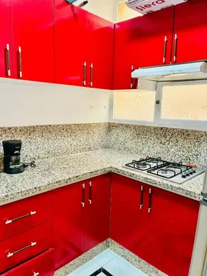 a kitchen with red cabinets and a stove at the sweet night of Marrakech in Marrakech