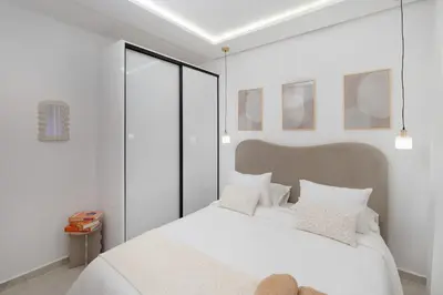 a white bedroom with a large white bed with white pillows at Dar élégant au centre de Marrakech piscine in Marrakech