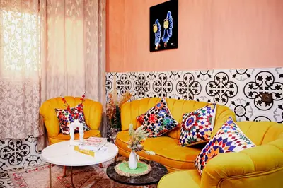 a living room with two yellow couches and a table at Appartement traditionnel au médina in Marrakech